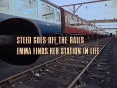subtitle card: pale yellow all caps text with black dropshadow to the left reading ‘STEED GOES OFF THE RAILS
			EMMA FINDS HER STATION IN LIFE’ superimposed on Lucas, a bit further down the siding beside the train